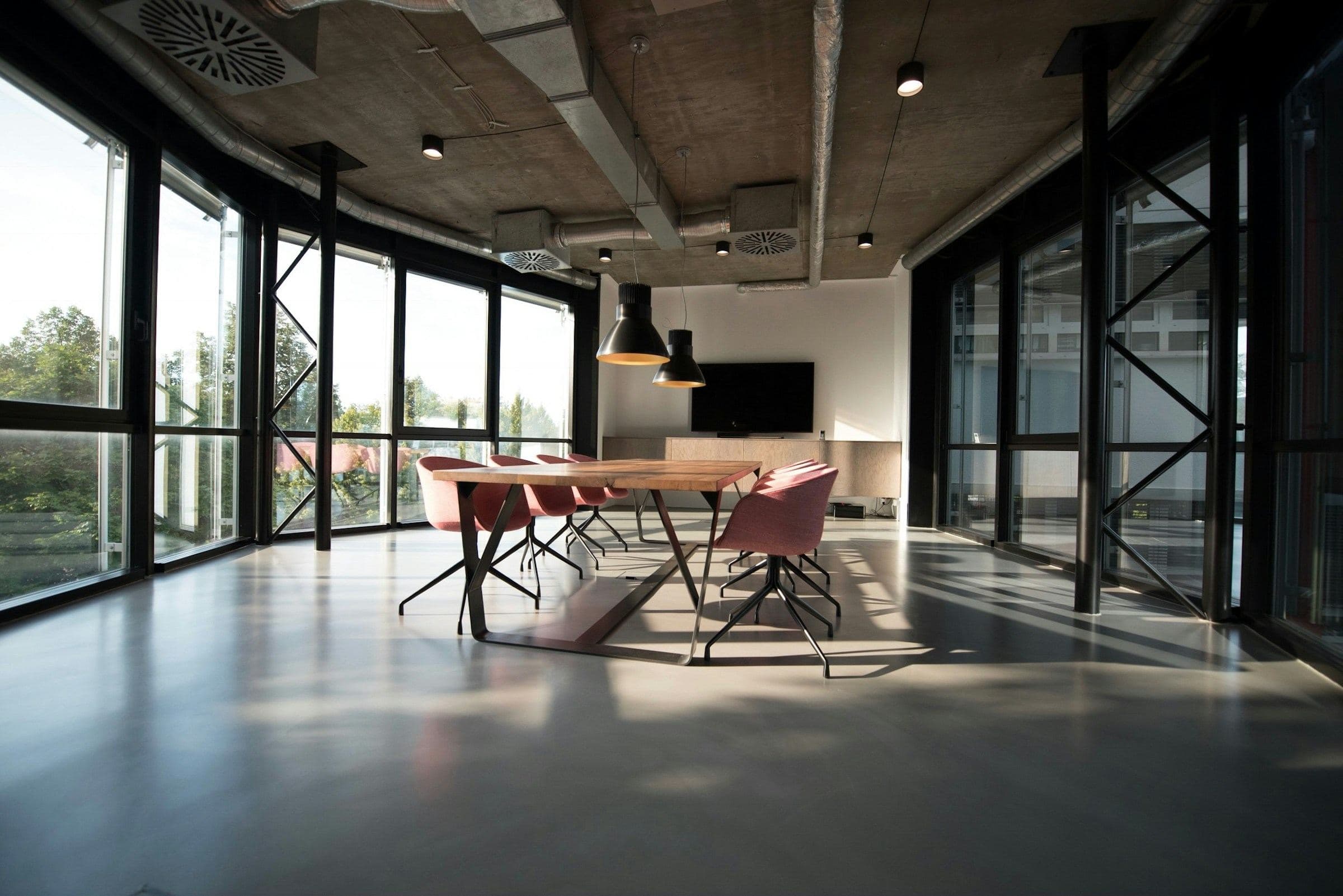Empty modern office with floor-to-ceiling windows and a long meeting table
